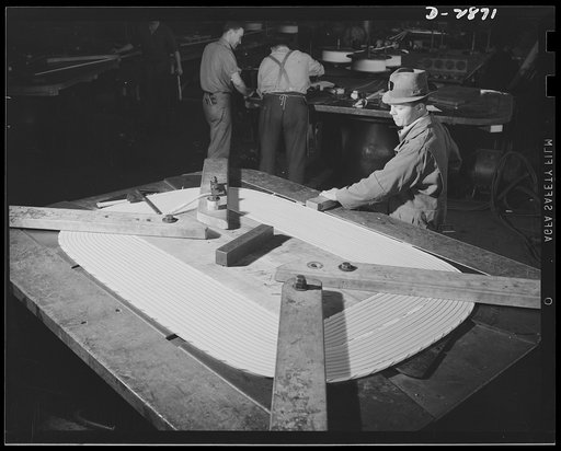 Transformer manufacture. The demand for power transformers has increased in America in direct ratio to the increase of war production. In this section of a large Eastern electrical plant, huge transformer coils are wound; this one may end up in a factory which is producing steel for Uncle Sam's ship