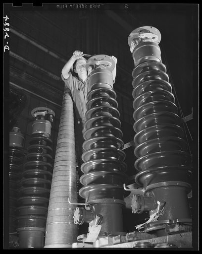 Transformer manufacture. These porcelain spirals are part of the works of a power transformer; transformers are essential to war production industries, and this employee of a large Eastern electrical company, working in the bushing section, is contributing essentially to Uncle Sam's war effort. Bush