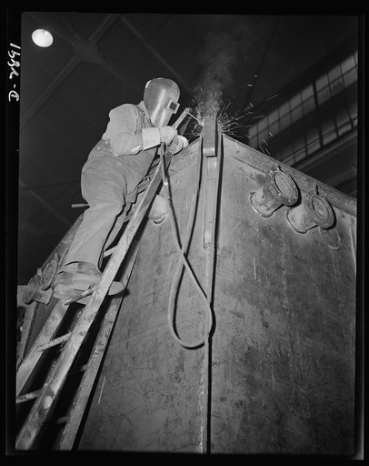 Transformer manufacture. Welding is an intrinsic part of the manufacture of transformers. This welder is employed by a large Eastern electrical company whose power transformers are needed by many factories engaged in war production. He's welding pipes on a power transformer tank. Westinghouse, Sharo