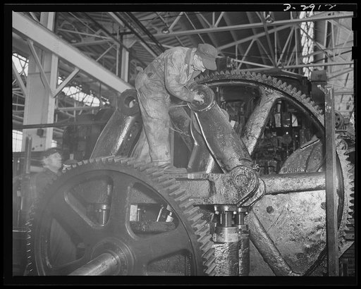 Conversion. Automobile plant. Toggle arm bearings of a big 90T96 Cleveland press are checked before the machine is reassembled for production of army truck parts in another building of an important automobile factory. The building that formerly housed the press is being entirely cleared for the manu