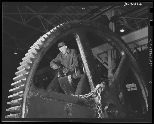 Conversion. Automobile plant. New Alemite fitting is added to a toggle arm bearing of a big 90T96 Cleveland press before the machine is reassembled in another building of an important automobile factory. The building that formerly housed the press is entirely cleared for the manufacture of an entire
