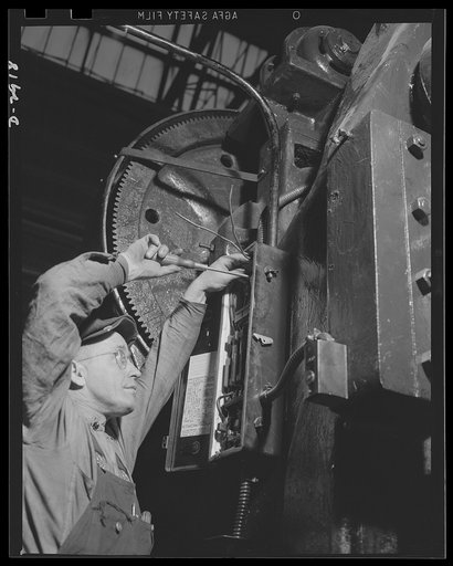 Conversion. Automobile plant. An electrical switch box is hooked up on a No. 9 1/2 big 90T96 Cleveland press, just relocated in an automobile factory to perform an operation on an army truck part. The old location of the press is devoted to tank production. Chevrolet Motors, Detroit, Michigan
