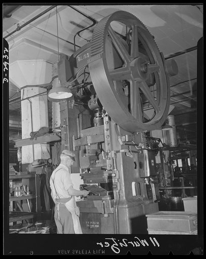 Conversion. Jukebox plant. It's all for fun now, but his technical skill in operating this 130-ton capacity die stamping press will soon be applied to far more important production. This employee of an Eastern jukebox manufacturing concern is shown stamping out mounting frames for jukeboxes. When th