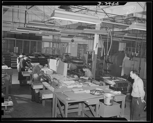 Conversion. Silverware plant. Undergoing conversion to production of bomb shackles from silver tableware, employees of an Eastern plant are helping America deal death to the Axis. On this assembly line, final touches are put on nearly-completed bomb shackles. Oneida Ltd., Oneida, New York