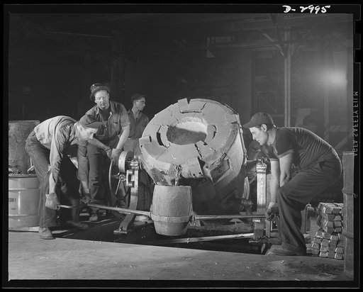 Aluminum casting. Sturdy workers in an aluminum plant pictured as they tap a 450-pound tilting-type crucible furnace to pour the molten into smaller gats from which further pourings are made. The finished product will be sent to a converted automobile factory or to an Eastern manufacturer of bomb si