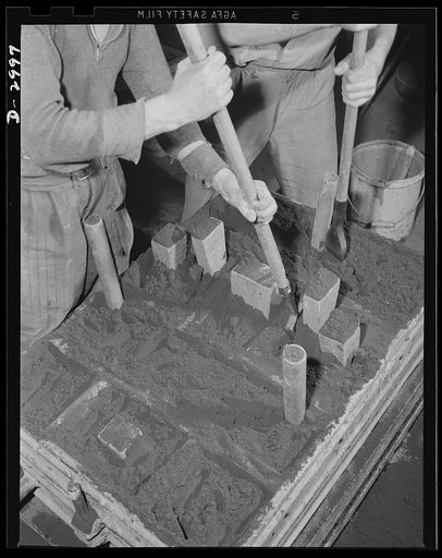 Aluminum casting. Hand packing of a sand mold. The sand must be firmly packed in order to insure against tiny vents and cracks which would mar the cast. Aluminum Industries Inc., Cincinnati, Ohio