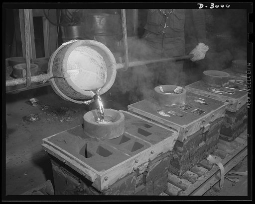 Aluminum casting. Closeup of the bright aluminum alloy being poured into molds. There may be no more aluminum for coffee percolators these days; it's going instead toward a much more vital purpose--war essentials for Uncle Sam's armed forces. Destination of the finished aluminum products is secret--
