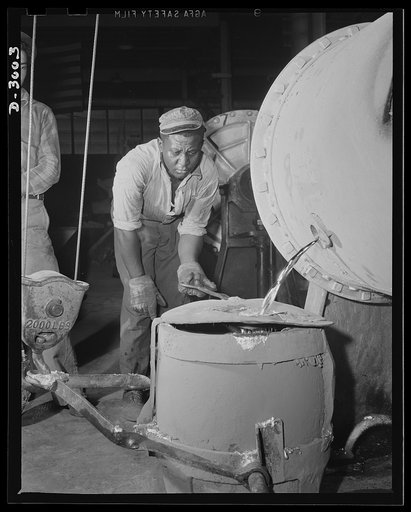 Aluminum casting. A husky Negro workman taps a 2,000-pound rotary furnace from which aluminum pours into carrying pot. Aluminum Industries Inc., Cincinnati, Ohio