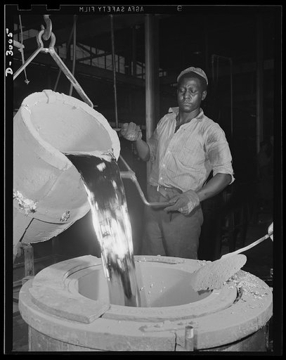 Aluminum casting. This bright white hot riser of aluminum is being poured from a 300-pound pot to a 300-pound holding pot. Molders will dip this holding pot to make castings. Aluminum Industries Inc., Cincinnati, Ohio