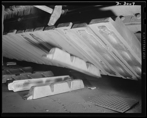 Aluminum casting. When the aluminum solidifies, it is knocked out by hammer from the ingot molds. Soon to be cast into essentials for the war effort, this metal is one of America's most vital essentials for victory. Destination of the finished aluminum products is kept secret--but they'll probably e