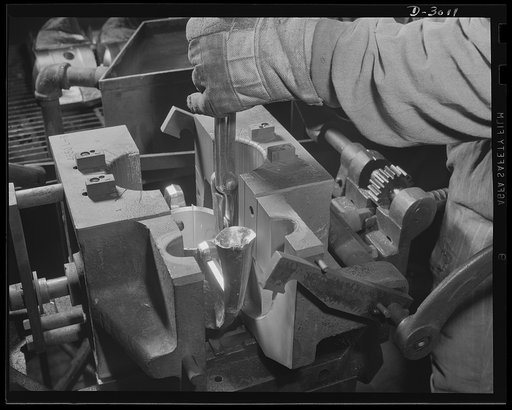 Aluminum casting. A skilled workman in a large Midwest aluminum foundry now converted to production of war materials removes the solidified casting from the permanent mold. Aluminum Industries Inc., Cincinnati, Ohio