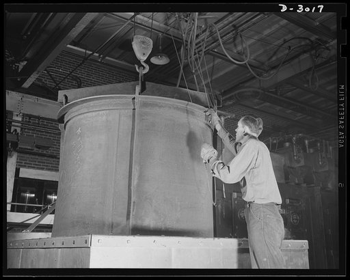 Aluminum casting. One of the many operations essential to production of aluminum articles for the Army and Air Forces: lowering basket into quench tank from high temperature heat treating solution furnace. Aluminum Industries Inc., Cincinnati, Ohio