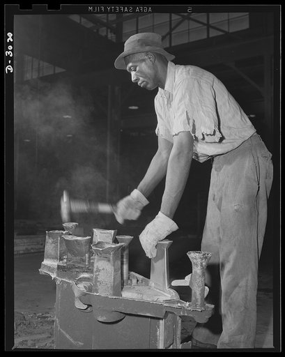 Aluminum casting. Knocking cores out of a sand casting, one of the myriad essential operations necessary to production of aluminum products. Aluminum Industries Inc., Cincinnati, Ohio