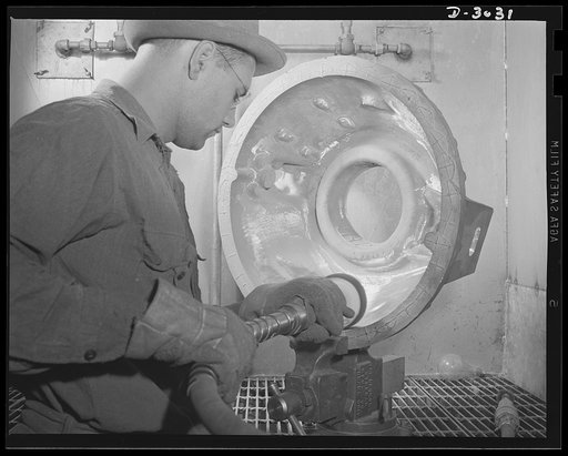 Aluminum casting. Stronger than aluminum, magnesium castings are cleaned and polished by a grinder. The casting is placed in a specially constructed hood to prevent fires. Aluminum Industries Inc., Cincinnati, Ohio