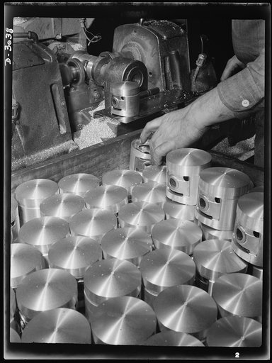 Aluminum casting. The reaming of pin holes in pistons. These bright cylinders are destined for use in the army's jeeps. They're among the war products of a huge Midwest aluminum foundry. Aluminum Industries Inc., Cincinnati, Ohio
