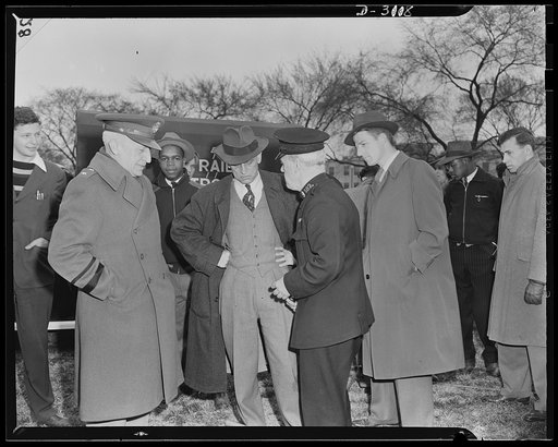Constable Scott of London (right) explains to Dean Landis, Office of Civilian Defense Director (center) and Major General L. D. Gasser, USA (left), the equipment of the Fauquier County Air Raid Patrol car (back) donated by Walter Chrysler to Fauquier County, Virginia. The car is a handsome model. Of