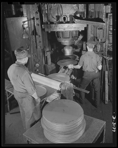 Conversion. Beverage containers to aviation oxygen cylinders. The first step in the manufacture of high-altitude-flying shatterproof oxygen cylinders in the metal department of a large rubber factory is the forming or stamping of the shell. Stainless steel sheets are blanked or cut into discs(left f