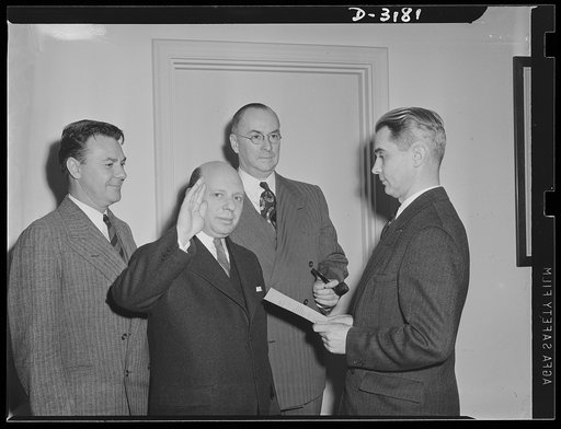 Administering oath. Left to right: John B. Blandford, Administrator of National Housing Agency; Herbert Emmerich, former Secretary of War Production Board, now Administrator of Defense Housing Authority; Donald M. Nelson, Chief, War Production Board and J.C. Hale, of Bureau of Budget, Assistant Admi