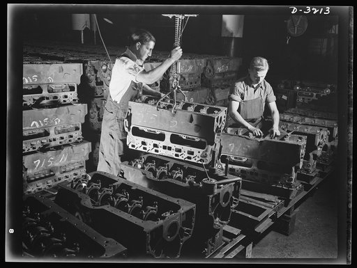 Halftrac scout cars. Laying the foundation of another power plant for an Army halftrac scout car. An engine block, already fitted with studs and bearing caps, starts its journey down the assembly line of a large Ohio plant. It will come off that line as part of a powerful, dependable engine, ready t