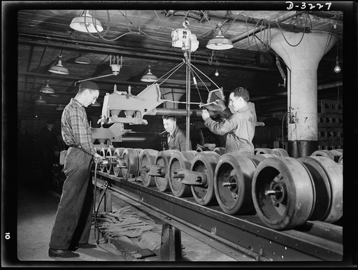 A bogy assembly for an Army halftrac scout car takes shape on the production line of an Ohio truck plant. When it's completed it must be able to stand rigid inspections. White Motor Company, Cleveland, Ohio