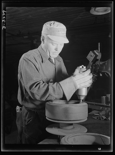 He's preparing rollers for a bogy assembly for a halftrac scout car produced, with many more like it, by a Midwest truck manufacturer. White Motor Company, Cleveland, Ohio