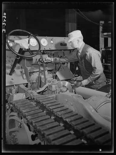 A halftrac scout car gets a touch-up job on the chassis assembly line of an Ohio truck plant. A durable finish protects the metal--and helps to bring the vehicle up to Army standards of smartness. White Motor Company, Cleveland, Ohio
