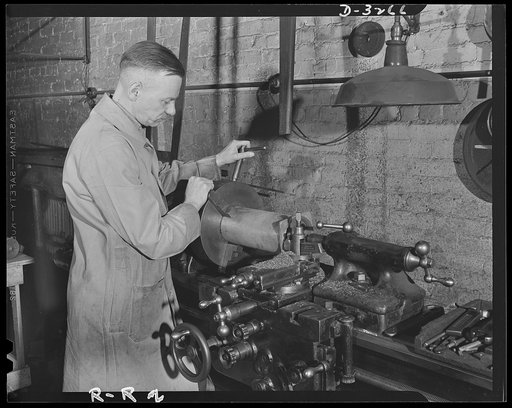 Oil burners to machine gun parts. Oil burners are the normal product of this Eastern factory now undergoing conversion to production of small precision parts for machine guns. This milling machine has not yet been converted to the war effort and is still turning out parts for burners. Reif-Rexoil Co