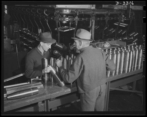 Accurate workmanship is required to make perfectly uniform shells for the Army. Inspectors are on the alert to reject those which fail to meet requirements. Oldsmobile, Lansing, Michigan