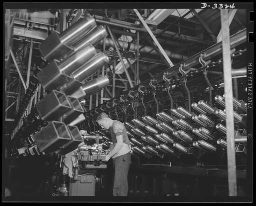 It's hard to recognize the production layout of a well-known auto plant in machine lines that win with wartime production. It's shells instead of auto parts now--but American industry can turn out the orders for war as well as for peace. Oldsmobile, Lansing, Michigan