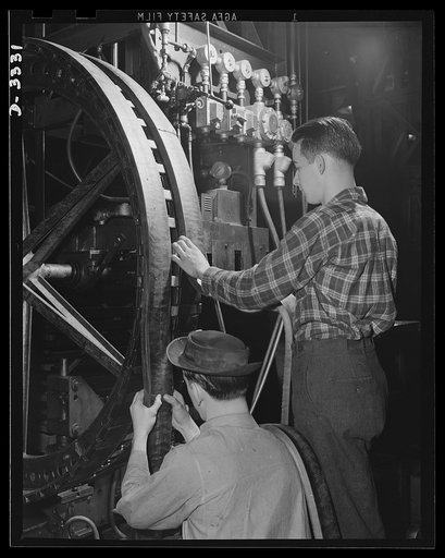 As the track for an Army halftrac develops to recognizable form on the "building wheel" of an Ohio tire plant, an important operation is performed by trained men. All rubber of the finished halftrac adheres firmly to steel bodies. Goodrich, Akron, Ohio