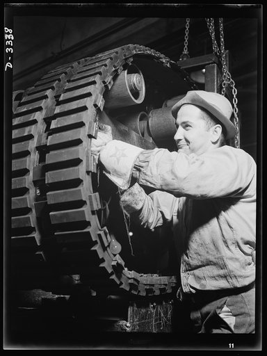 Another sturdy track for an Army halftrac car will soon be ready for use. On the trimming rack of the Ohio tire plant in which it was made curing plates and overflowing edges of rubber are removed. Goodrich, Akron, Ohio
