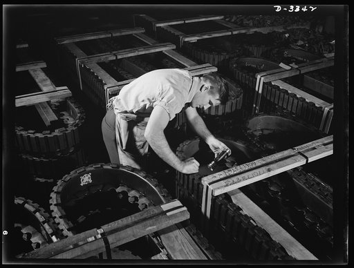 The serial numbers of each track for Army halftrac vehicles crated for shipment from a Midwest tire plant are given a final check. Goodrich, Akron, Ohio