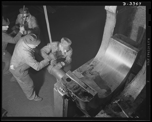 A bearing of a big forge hammer is removed for overhauling as the maker of a popular American car switches over to production of machine guns for the Air Force. Every machine in the plant must be in perfect condition for big orders in the months to come. Oldsmobile, Lansing, Michigan