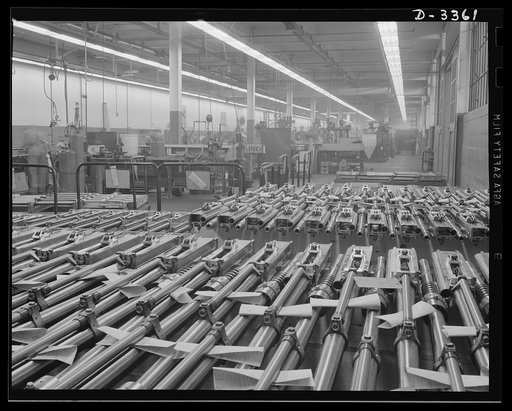 Twenty-millimeter machine guns for planes. American power in the air grows rapidly as machine guns of the finest quality pour from production lines to arm the planes that are coming steadily from other lines. These guns, entirely completed and ready to fire, await shipment from the large converted a