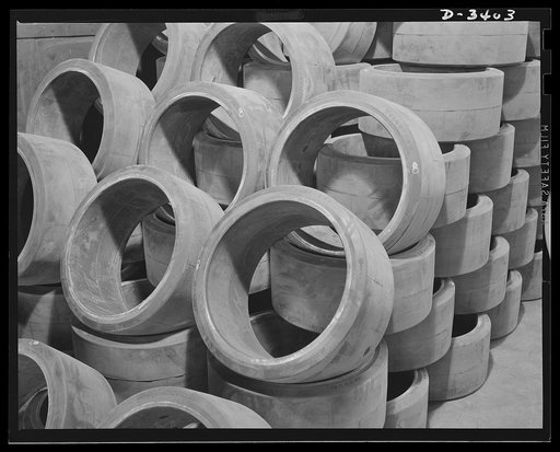 Conversion. Heaters to bogie wheels. Ready for final assembly, these bogie wheel tires have been stacked in a converted Midwest heater factory. These M-4 tank accessories are not produced in the company's old warehouse. They're sinkers with a tough job ahead to help sink the Axis