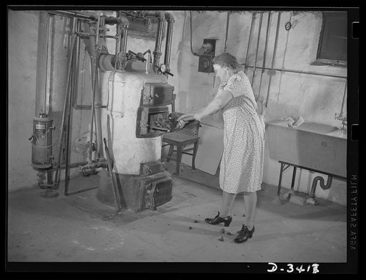 Women at war (Mrs. Smuda). She gives half her day to Uncle Sam and the other half to her home and family. Firing the furnace looks like a man-sized job, but Mrs. Smuda has reduced it to a system. Note that short handled shovel to make the job easier