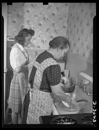 Women at war (Mrs. Smuda). There's a war to be won, but there's work to be done at home, and this modern warrior-mother enjoys taking a hand in household duties. Tonight, she's washing the supper dishes while her daughter Genevieve dries