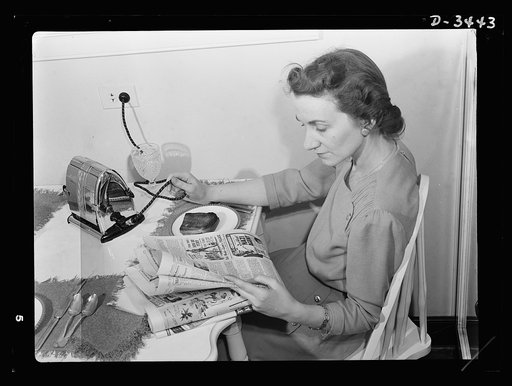 What's wrong with this picture? Only that the lady is ruining her electric cord by disconnecting the toaster the wrong way. Don't pull cords from irons or toasters: disconnect them gently at the wall socket