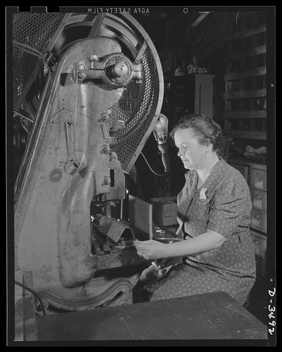 Conversion.Toy furniture to dies for incendiary bombs. The hands that rocks the cradle can also rock the Axis. American women are rapidly taking their places on the industrial front. Here in this small Midwest factory, the owner's wife operates one of the machines making dies for incendiary bombs. S