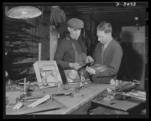 Conversion. Toy furniture to dies for incendiary bombs. Owner and foreman of this small Midwest factory check final pieces of doll's metal furniture before the shop is given over entirely to war production. In foreground are tools and dies which made the toys. All of the equipment will be converted 