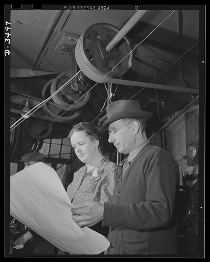 Conversion. Toy furniture to dies for incendiary bombs. More space for making bomb dies. The owner of a small factory and his wife inspect blue prints of the addition they need to accomodate their war production, on orders. Fifty, instead of seven men, will man the new shop. Sivon Machine Company, P