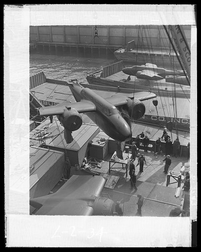 Lend-lease in action. American war planes, provided through lend-lease, are in action on the various fighting fronts. Lend-lease twin engine bombers are shown being hoisted aboard ship in an unnamed American port from a lighter alongside. They are bound for distant Allied ports. More bombers in the 