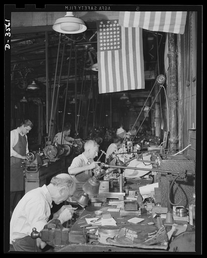 Conversion. Watch cases to war production. Conversion, all the day. The fourty-five star flag above a worker in a converted watch case factory marks a soldier of the firing line of '98, now a soldier of the production line of '42. The plant makes small carbine and machine gun parts, compass cases an