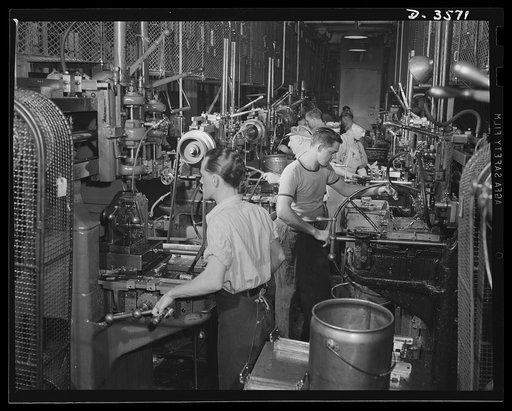 Mouthpiece forgings for 20mm anti-aircraft gun magazines travel down the rows of milling machines that prepare them for the assembly line. The plant doing the work used to make cash registers. National Cash Register Company, Dayton, Ohio
