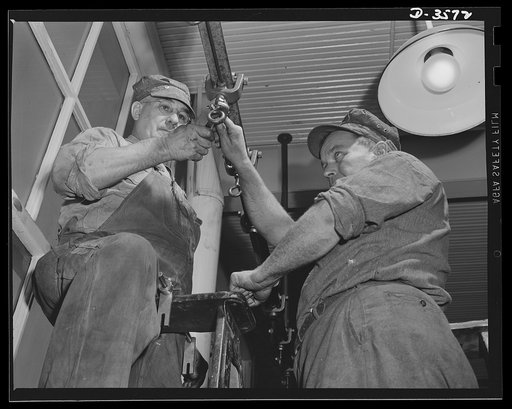Installing a new conveyer in a converted cash register manufacturing plant. The plant is now turning over magazines for 20mm anti-aircraft guns. National Cash Register Company, Dayton, Ohio