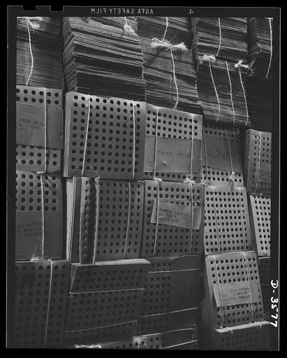 A converted cash register factory now producing war goods in enormous volume must keep on hand huge stocks of packing materials. These corrugated board inserts are made from waste paper and are used for packing shell parts. National Cash Register Company, Dayton, Ohio