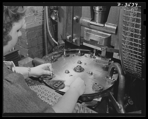 A dial feed press crimps 20mm fuses in a large plant which quickly changed over to the production of essential supplies for our armed forces. National Cash Register Company, Dayton, Ohio