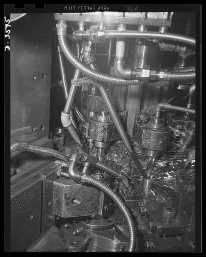 Conversion. Cash registers to gun magazines. A multi-spindle screw machine that formerly worked on cash register parts now performs a first operation on 37mm M-54 high explosive shells. National Cash Register Company, Dayton, Ohio