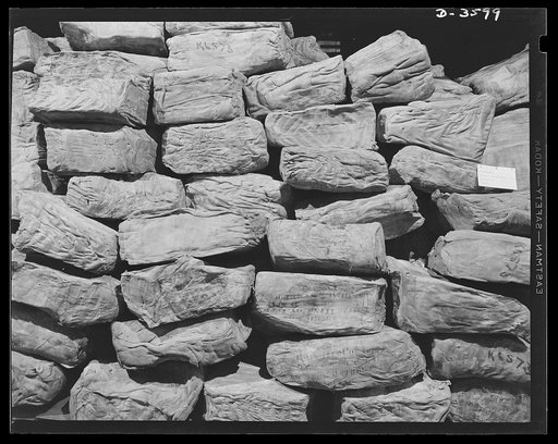 Rubber in storage. Preferred stock. It's crude rubber -- and there's more in many warehouses throughout the country to meet our war needs. The 250-pound bales, wrapped in burlap or packed in boxes, are stored in heating and thawing rooms until they attain the proper temperature for processing