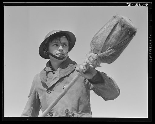 Fort Story coast defense. Poised ready to quench burning fragments after one of Fort Story's six-inch guns is fired, this soldier prepares the gun for another powder charge